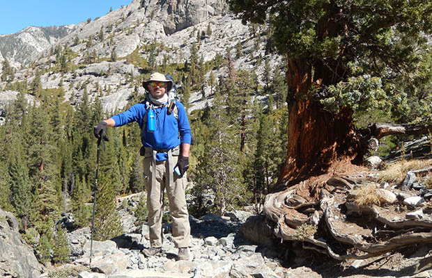 Ben Spillman standing by the Sierra Juniper at John Muir Corner