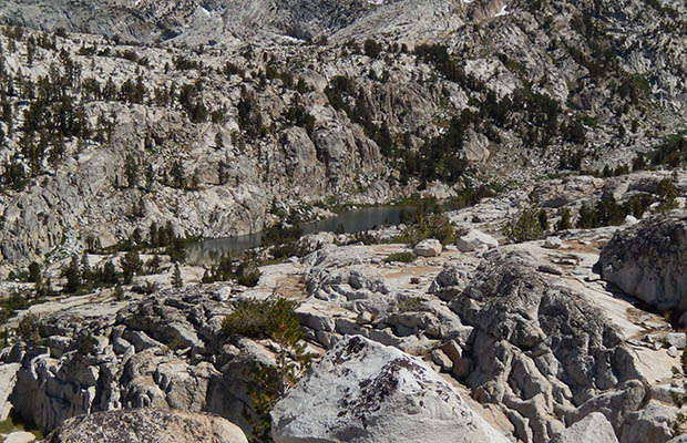 Izaak Walton Lake surrounded by steep granite slabs and cliffs.