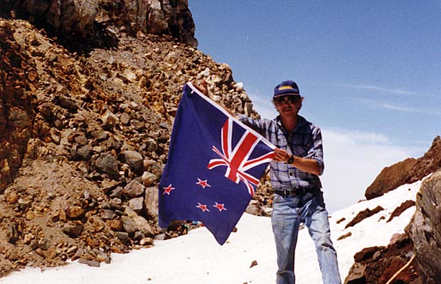 Graham on the summit of Mount Egmont in 1991, proudly holding the New Zealand flag.