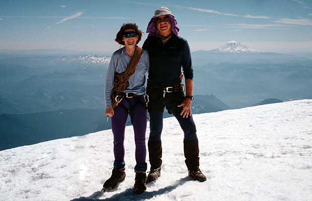 Lucy and Peter on the summit of Rainier, with the Goat Rocks & Mt Adams behind 